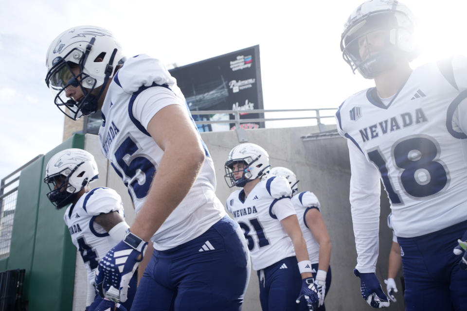 Nevada tight end Cameron Zeidler, left, and wide receiver Spencer Curtis head out to warm up before an NCAA college football game against Colorado State, Saturday, Nov. 18, 2023, in Fort Collins, Colo. (AP Photo/David Zalubowski)