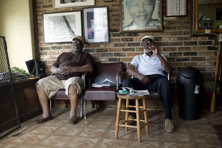 Lenny Clay (R) sits at his barber shop in Baltimore, Maryland April 29, 2015. REUTERS/Eric Thayer