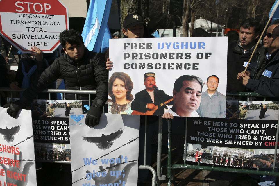 FILE - In this March 15, 2018, file photo, Uighurs and their supporters rally across the street from United Nations headquarters in New York. Members of the Uighur Muslim ethnic group are calling on China to post videos of their relatives who have disappeared into a vast system of internment camps. The campaign follows the release of a state media video showing famed Uighur musician Abdurehim Heyit, who many believed had died in custody. (AP Photo/Seth Wenig, File)