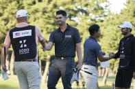 Beau Hossler of the United States, center left, and Justin Suh of the United States, center right, shake hands with caddies on the eighteenth green the PGA Tour Zozo Championship at the Narashino Country Club in Inzai on the outskirts of Tokyo, Sunday, Oct. 22, 2023. (AP Photo/Tomohiro Ohsumi)