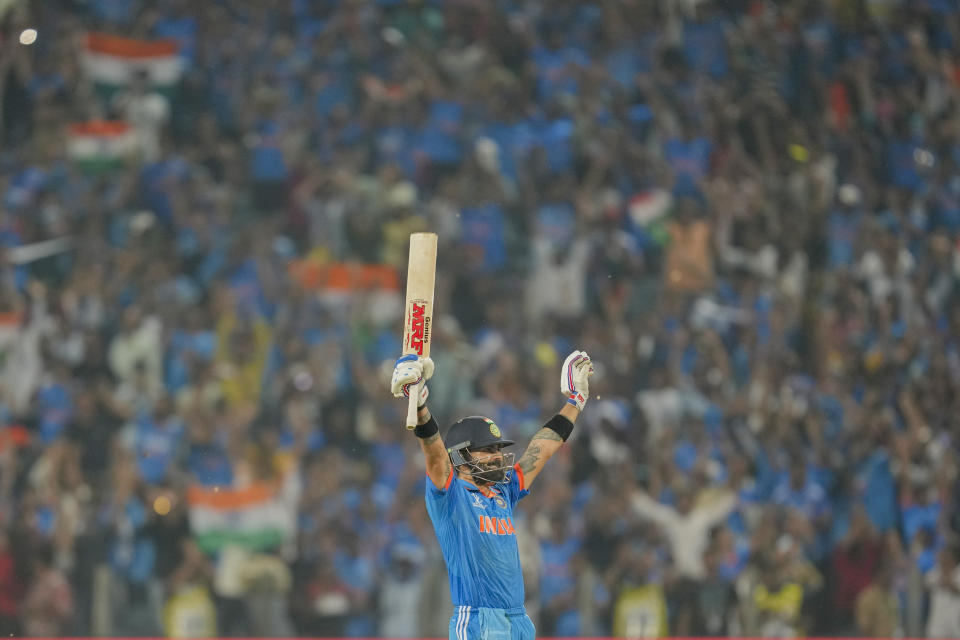 India's Virat Kohli raises his bat as he celebrates his century during the ICC Men's Cricket World Cup match between Bangladesh and India in Pune, India, Thursday, Oct. 19, 2023. (AP Photo/ Rafiq Maqbool)