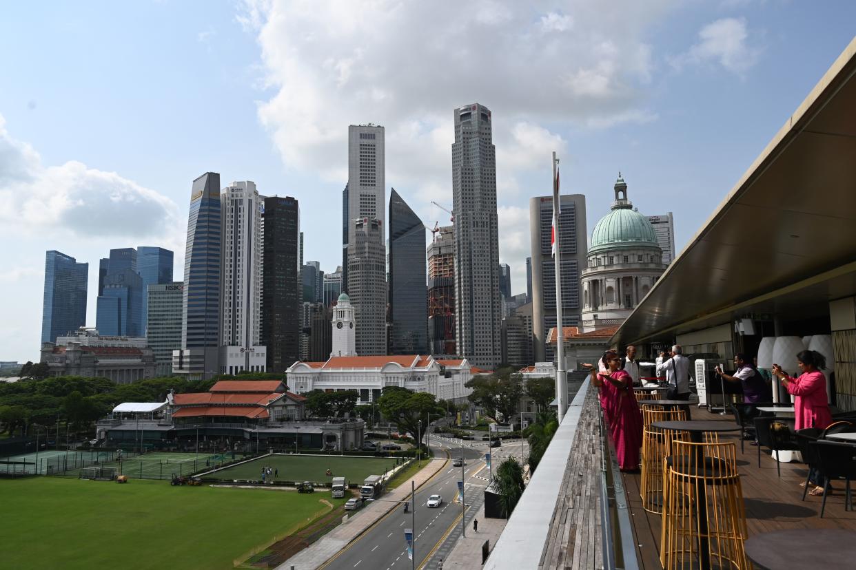 Singapore's city skyline is seen as visitors take photographs from the rooftop bar of the National Gallery on January 13, 2020. (Photo by Roslan RAHMAN / AFP) (Photo by ROSLAN RAHMAN/AFP via Getty Images)