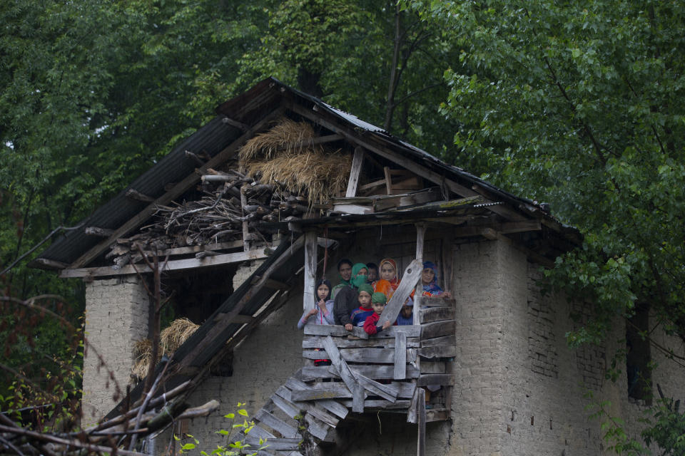 Kashmiri villagers watch the funeral procession of Zakir Musa, a top militant commander linked to al-Qaida, as it rains in Tral, south of Srinagar, Indian controlled Kashmir, Friday, May 24, 2019. Musa was killed Thursday evening in a gunfight after police and soldiers launched a counterinsurgency operation in the southern Tral area, said Col. Rajesh Kalia, an Indian army spokesman. (AP Photo/Dar Yasin)