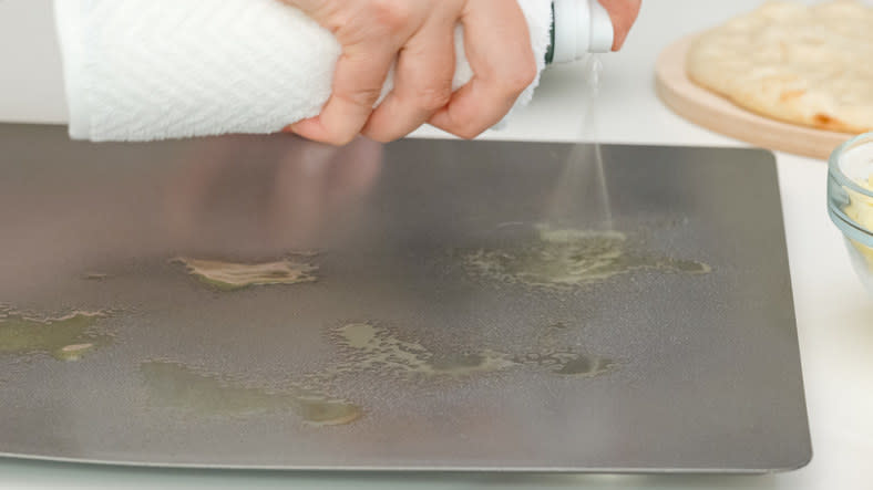 pan being sprayed with oil