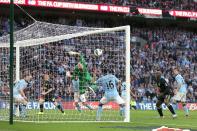 Wigan Athletic's Ben Watson (obscured) scores the winning goal past a helpless Manchester City goalkeeper Joe Hart