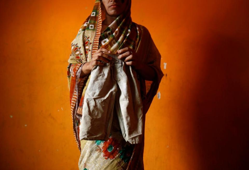 Chandravati poses with trousers belonging to her missing three-year-old daughter, Muskaan, inside her house in New Delhi.