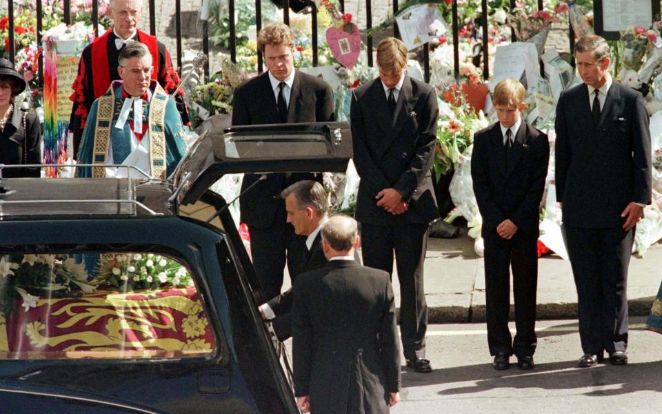 Earl Spencer, Prince William, Prince Harry and Prince Charles watch as the coffin of Diana, Princess of Wales is placed into a hearse at Westminster Abbey following her funeral service - Credit: Kieran Doherty 