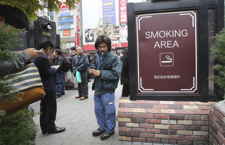 People gather at the smoking area in Tokyo, Friday, April 7, 2017. The senior World Health Organization official says Japan should go fully smoke-free in public places if it wants success in Tokyo Olympics and tourism promotion. (AP Photo/Koji Sasahara)