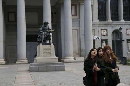 Tourists take a selfie beside a statue of Spanish painter Diego Velazquez outside El Prado Museum in central Madrid, Spain, January 18, 2016. REUTERS/Susana Vera