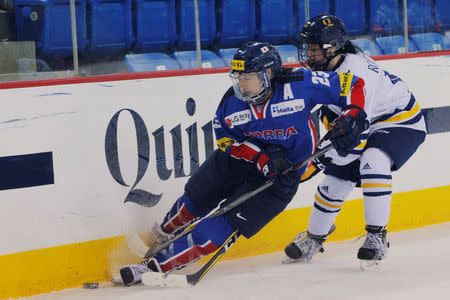 South Korean women's ice hockey player Marissa Brandt reaches the puck ahead of Quinnipiac University's Allison Roethke (R) during a game in Hamden, Connecticut, U.S., December 28, 2017. REUTERS/Brian Snyder