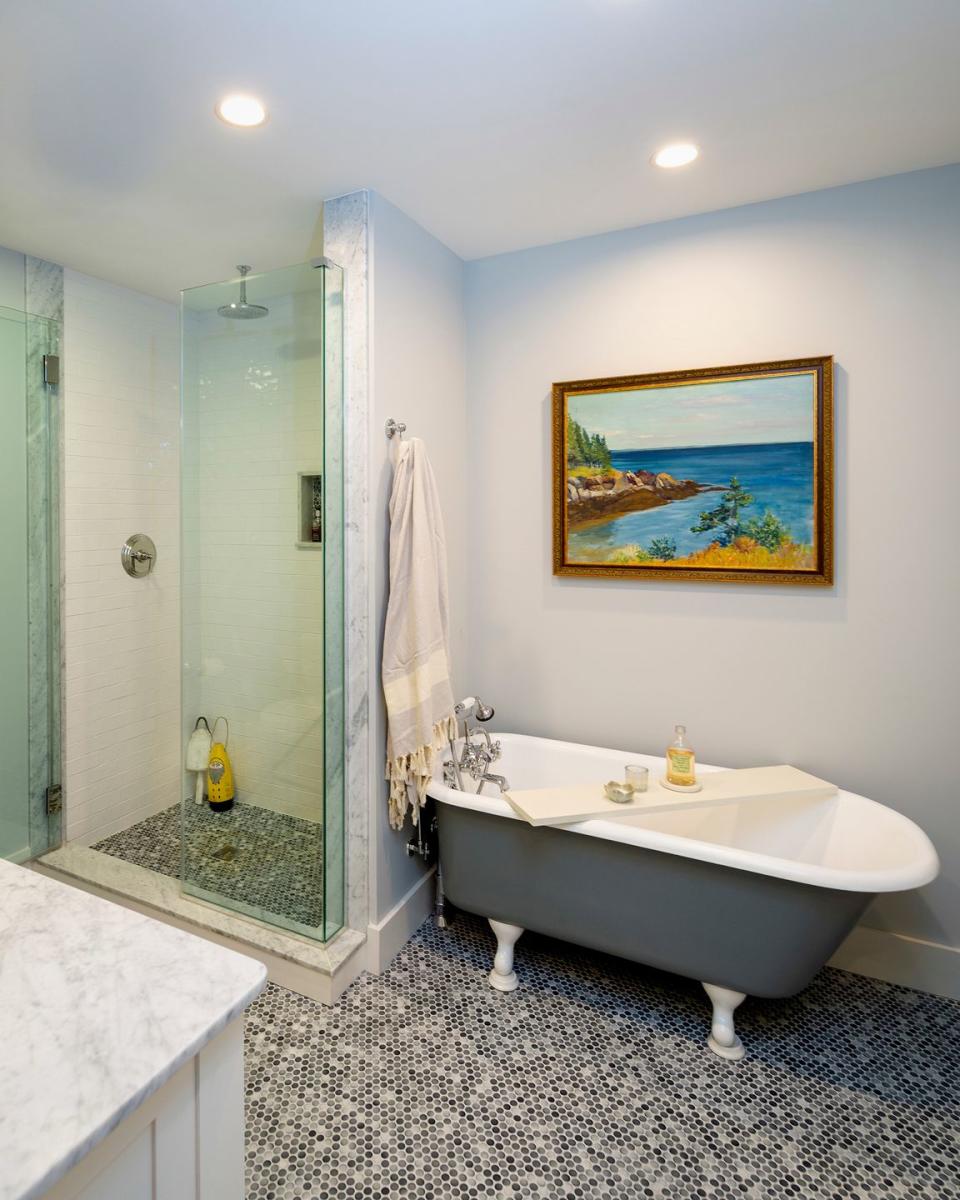 baño con bañera clásica y suelo de azulejos en mosaico