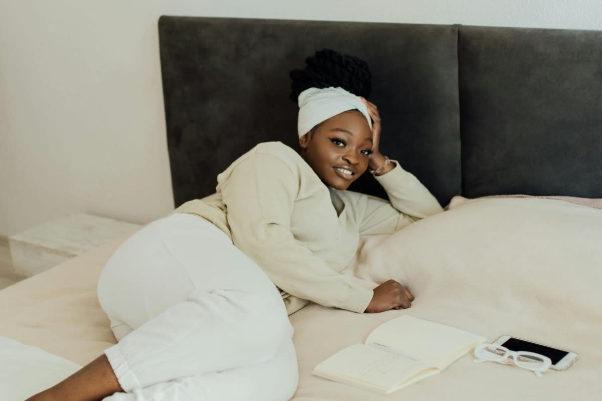 woman relaxing in hotel room bed