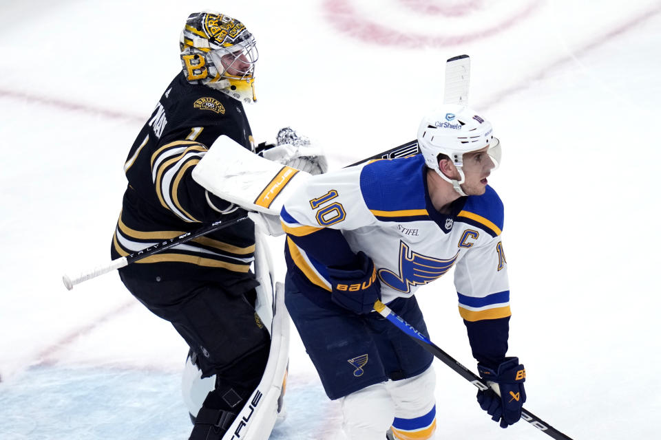 Boston Bruins goaltender Jeremy Swayman (1) tries to clear St. Louis Blues center Brayden Schenn (10) away from the crease during the first period of an NHL hockey game, Monday, March 11, 2024, in Boston. (AP Photo/Charles Krupa)