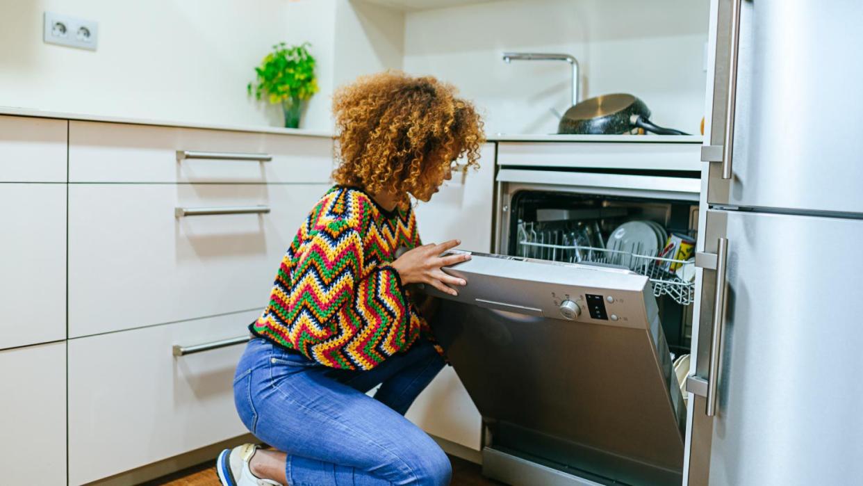 Woman opening the dishwasher