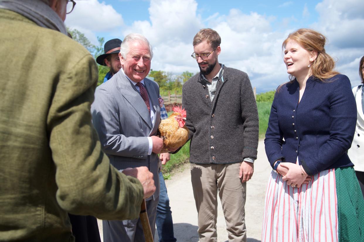 MUNICH, GERMANY - MAY 10: Prince Charles, Prince of Wales, holds a chicken alongside Sophie Schweinsfurth and Mathias Stinglwagner during a visit to the organic farm Herrmannsdorfer Landwerkstaetten on May 10, 2019 in Glonn near Munich, Germany. Their Royal Highnesses are paying an official visit to Germany at the request of the British government. The four-day-trip from May 7-10  will include visits to Berlin, Leipzig and Munich. (Photo by Pool/Getty Images)