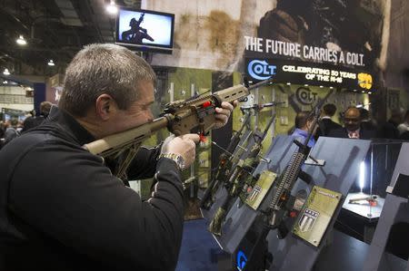 Mark Heitz, of Tactical Firearms in Kingston, New Hampshire, looks over a civilian version of the Colt M4 carbine during the annual SHOT (Shooting, Hunting, Outdoor Trade) Show in Las Vegas January 15, 2013. REUTERS/Las Vegas Sun/Steve Marcus/File Photo