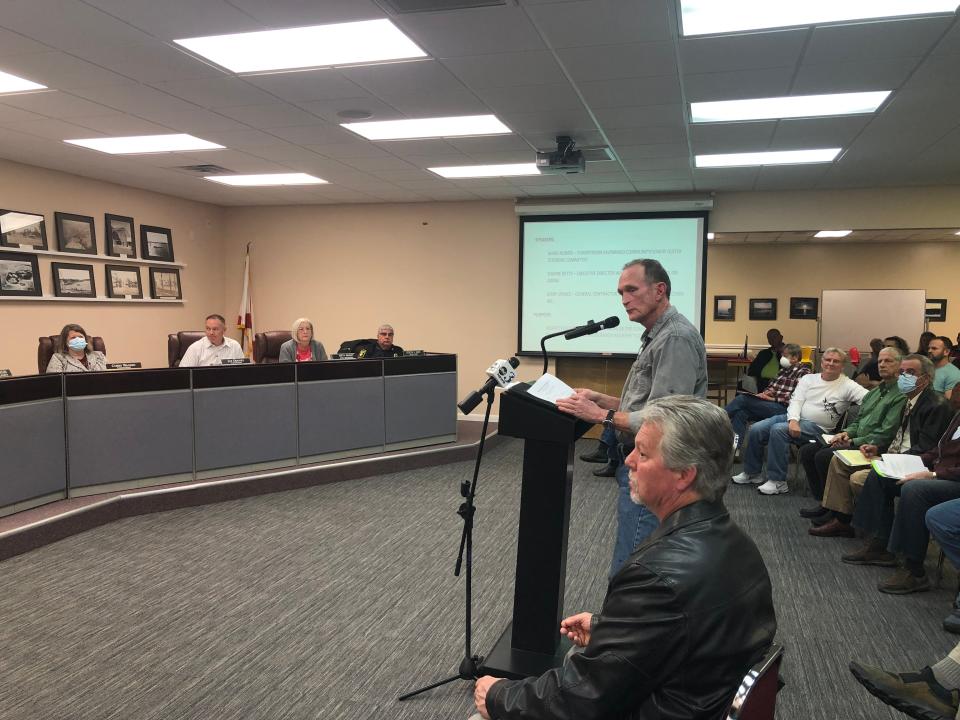 Local general contractor Jerry Spence, at the microphone, addresses the Valparaiso City Commission at its Monday night meeting, telling them he found "no significant problems" with the city's century-old community center during a recent inspection, other than problems with its roof. In the foreground is Mark Norris, a former Valparaiso fire chief and a leader of the effort to save the building. Dozens of people attended the Monday commission meeting in support of reopening the community center.