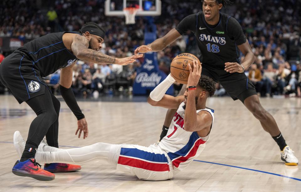 Detroit Pistons forward Troy Brown Jr. (7) looks to pass the ball as Dallas Mavericks guard Jaden Hardy, left, and forward Olivier-Maxence Prosper (18) defend during the second half of an NBA basketball game Friday, April 12, 2024, in Dallas. (AP Photo/Jeffrey McWhorter)