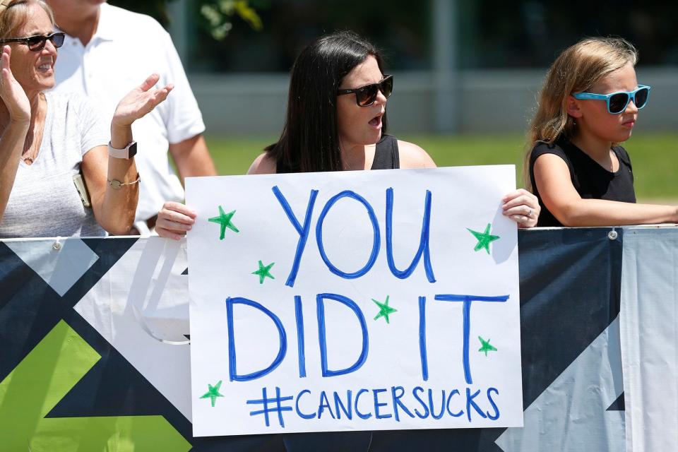 Kelly Allgeier, holding sign, came from Tampa to see her sister, Alissa Durbin, of Columbus, finish a 55-mile ride at Kenyon College in Gambier during Pelotonia on in 2018.