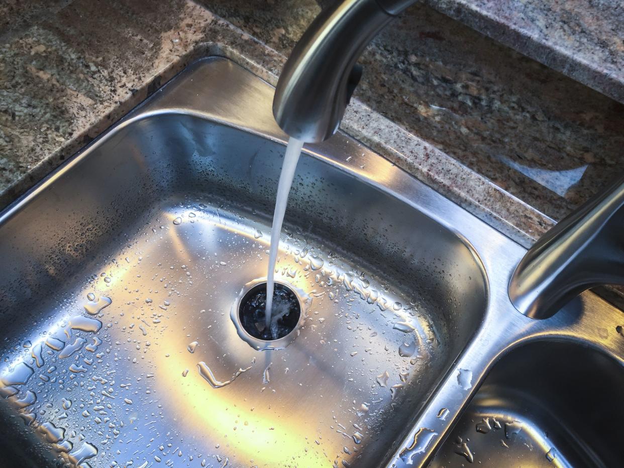 Water down the drain of kitchen sink.