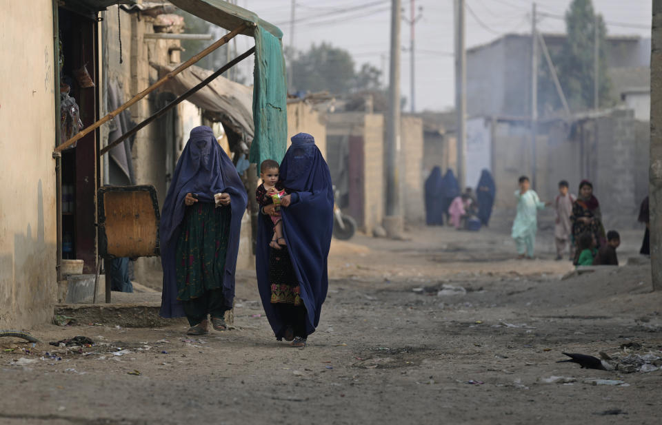 Burqa-clad Afghan women walk on a street in a a neighbourhood, where mostly Afghan populations, in Karachi, Pakistan, Friday, Jan. 26, 2024. For more than 1 million Afghans who fled war and poverty to Pakistan, these are uncertain times. Since Pakistan announced a crackdown on migrants last year, some 600,000 have been deported and at least a million remain in Pakistan in hiding. They've retreated from public view, abandoning their jobs and rarely leaving their neighborhoods out of fear they could be next. It's harder for them to earn money, rent accommodation, buy food or get medical help because they run the risk of getting caught by police or being reported to authorities by Pakistanis. (AP Photo/Fareed Khan)