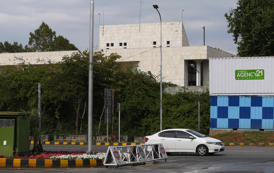 A car drives past the French Embassy, in Islamabad, Pakistan, Thursday, April 15, 2021. The French embassy in Pakistan on Thursday advised all of its nationals and companies to temporarily leave the country after anti-France violence erupted in the Islamic nation over the arrest of a radical leader. Saad Rizvi was arrested Monday for threatening the government with mass protests if it did not expel French envoy Marc Baréty over the publication depictions of Islam’s Prophet Muhammad. (AP Photo/Anjum Naveed)