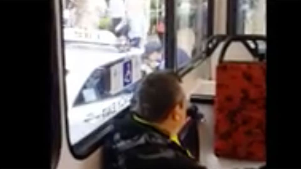 The bus driver can seen reaching through the taxi driver's window to hit him. Photo: Shinobi/Vidme