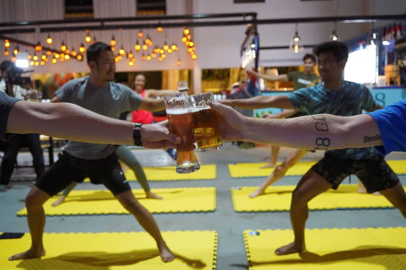 People participate in a beer yoga session, as the country eases COVID-19 restrictions, at a craft brewery in Phnom Penh