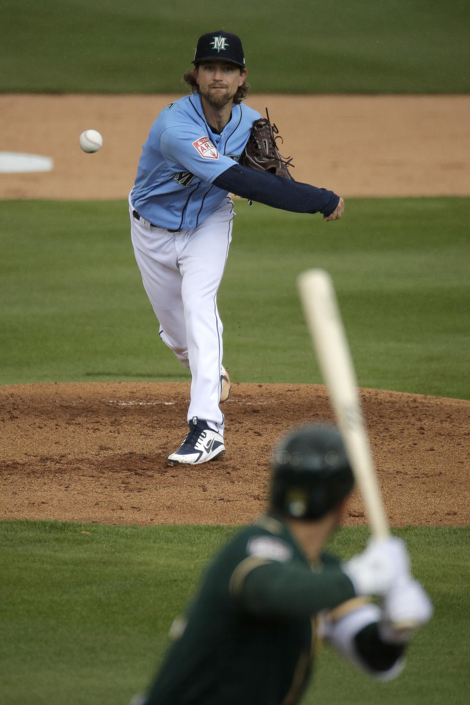 Seattle Mariners starting pitcher Mike Leake, top, throws to Oakland Athletics' Ramon Laureano during the first inning of a spring training baseball game Friday, Feb. 22, 2019, in Peoria, Ariz. (AP Photo/Charlie Riedel)