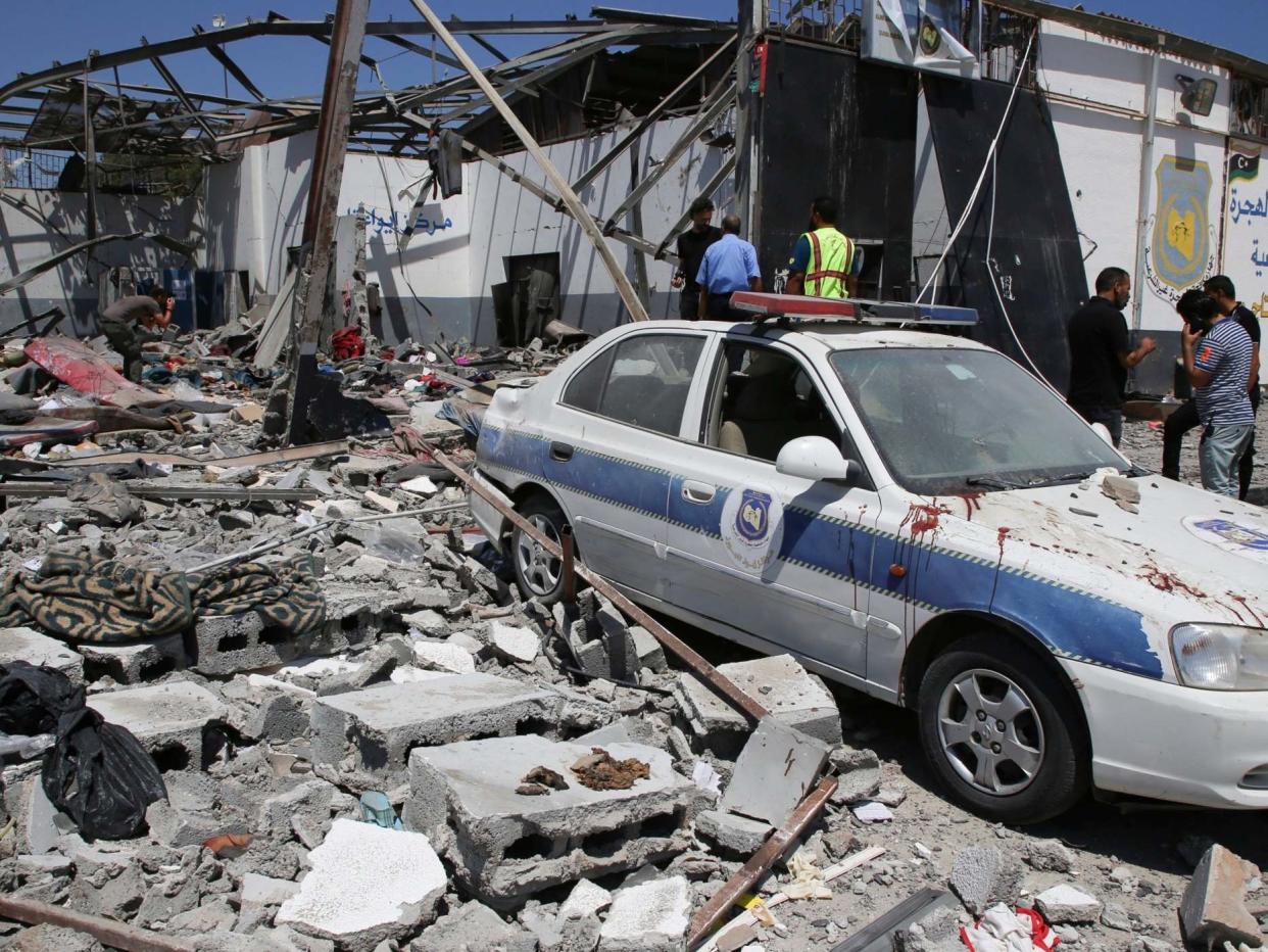 Debris covers the ground and an emergency vehicle after an airstrike at a detention center in Tajoura, east of Tripoli in Libya: AP