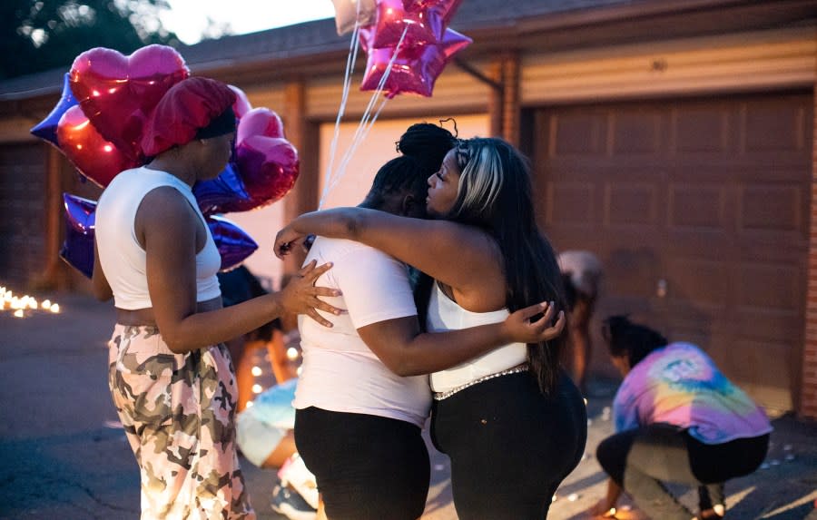 Friends comfort each other at a private candlelight vigil Friday, Aug. 25, 2023, in Columbus, Ohio, held for 21-year-old Ta’Kiya Young, who was shot and killed a day earlier by Blendon Township police outside an Ohio supermarket. (Courtney Hergesheimer/The Columbus Dispatch via AP)