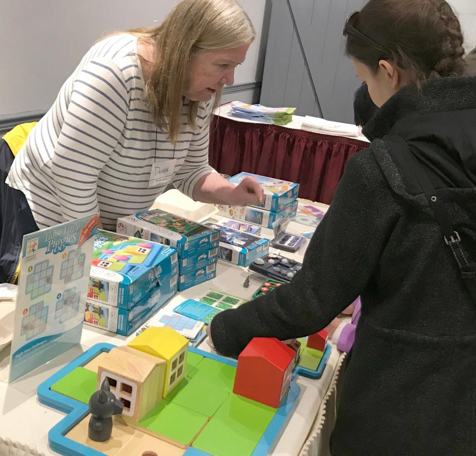 Denise Cavanaugh teaches a game in the Smart Toys and Games booth at the 2019 BroCoCon. The game on display springs off the story of the three little pigs, their homes and the big bad wolf.