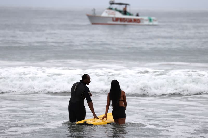 People walk into the ocean at The Black Girls Surf paddle-out in memory of George Floyd, who died in Minneapolis police custody, in Santa Monica