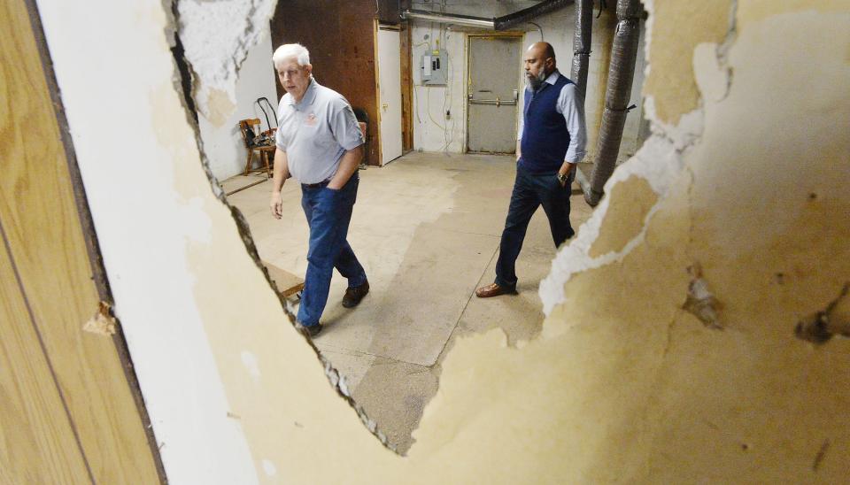 Business partners Kevin Kujan, left, and Ankur Shah, walk through a retail building being renovated into another D-Express Laundry last week in Wesleyville. The new east side location will be about 3,400 square feet or almost twice the size of the original laundry, located on West 12th Street at Powell Avenue in Millcreek Township.