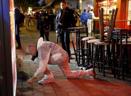 An Israeli forensic policeman works at the scene of a shooting rampage by Israeli Arab Nashat Melhem at a bar in Tel Aviv, in this January 1, 2016 file picture. REUTERS/Baz Ratner/Files