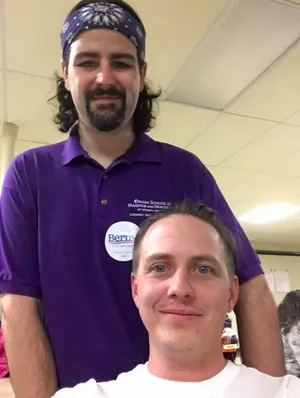 Tom Anderson, standing, was punched in the face during a homophobic attack in 2020. He is pictured here with his husband Jacob.