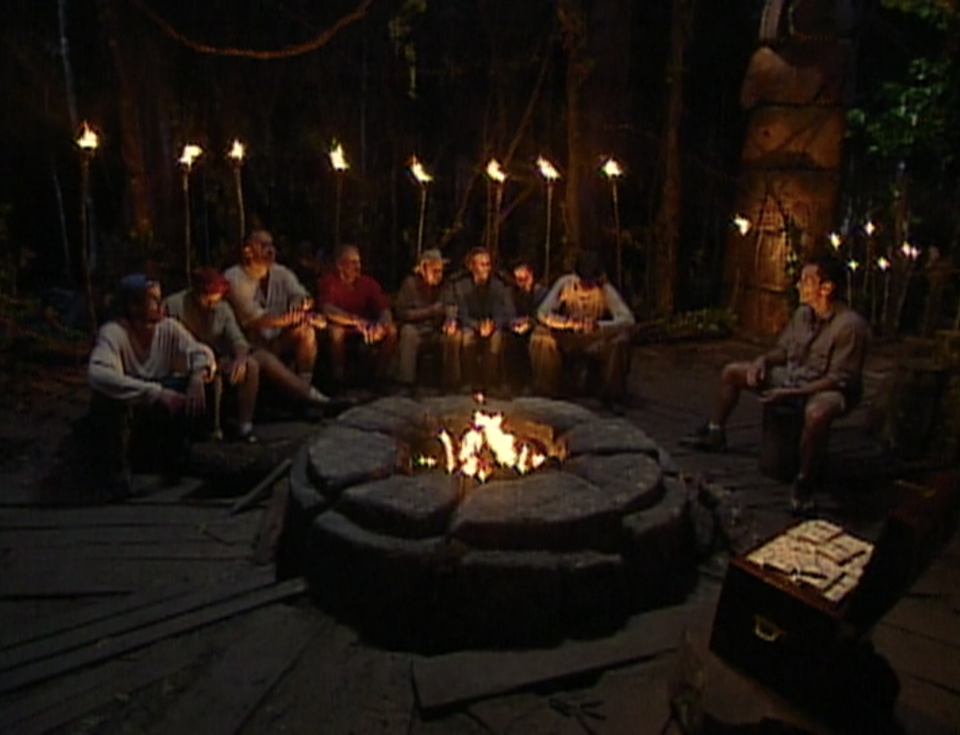 The tribe sits at Tribal Council across from a large chest of money in Survivor: Borneo