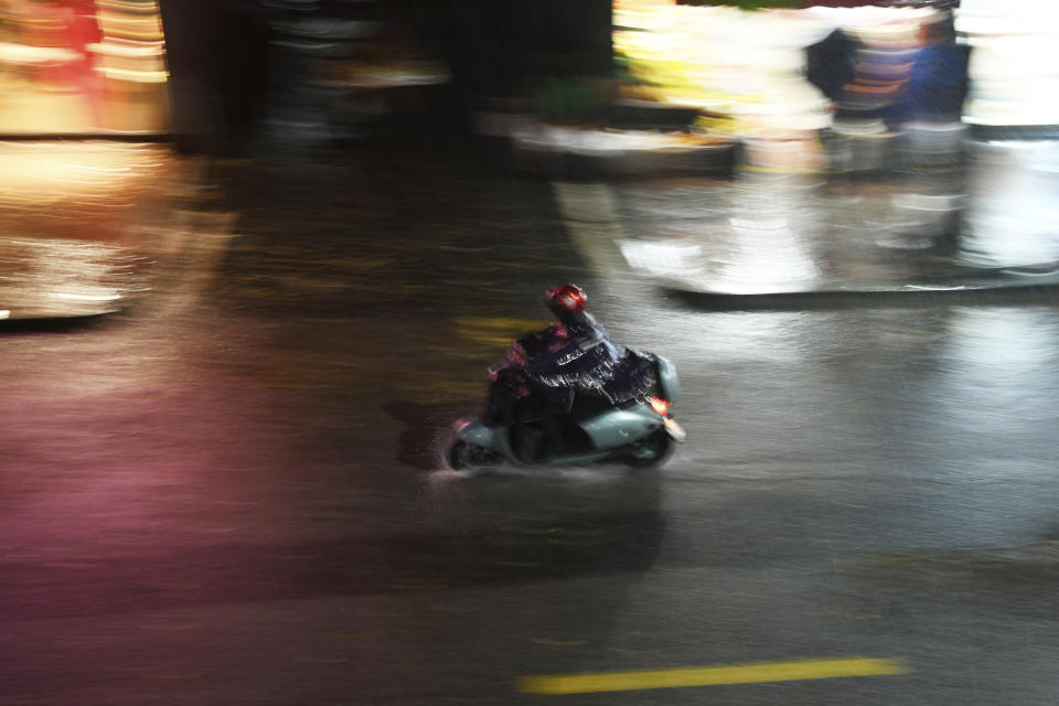 A motorcyclist passes through a rain storm in Nanchang in eastern China's Jiangxi province Tuesday, April 2, 2024. Violent rain and hailstorms have killed some people in eastern China's Jiangxi province this week, including people who fell from their apartments in a high-rise building. (Chinatopix Via AP) CHINA OUT