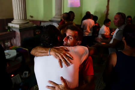 Worshippers and activists supporting the lesbian, gay, bisexual and transgender community (LGBT) react during a service at the Metropolitan Community Church (MCC) in Matanzas, Cuba, October 12, 2018. REUTERS/Alexandre Meneghini