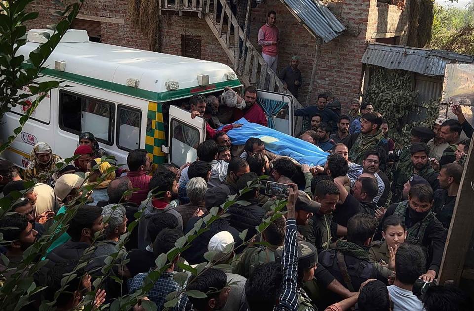 People carry the body of Puran Krishan Bhat, who is from the minority community of Kashmiri Hindus, outside his home in in southern Shopian district, Indian controlled Kashmir, Saturday, Oct. 15, 2022. Assailants on Saturday fatally shot Bhat in violence police blamed on militants fighting against Indian rule in the disputed region. (AP Photo/Faizan Mir)