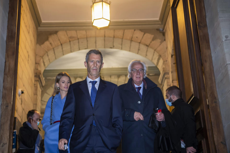 Lawyers Camille Haab, left, and Marc Bonnant, right, lawyer for Israeli businessman and diamond magnate Beny Steinmetz, at center, leaving the courthouse in Geneva, Switzerland, Friday Jan. 22, 2021. Mining tycoon Steinmetz has been sentenced to five years in jail and fined dollars 56.5m after being found guilty of bribery, Friday. Steinmetz said he would appeal against the judgment. (Martial Trezzini/Keystone via AP)