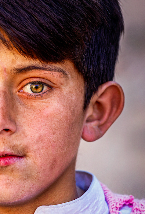 This shows a young boy from Pakistan with striking eyes.