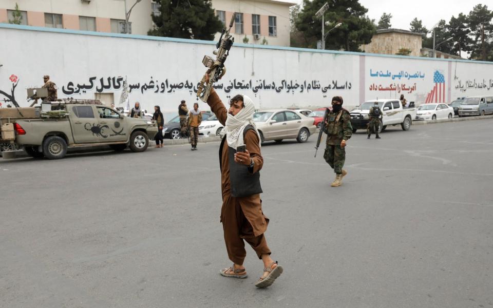 A Taliban fighter celebrates on the first anniversary of the fall of Kabul on a street in Kabul, Afghanistan - ALI KHARA/REUTERS