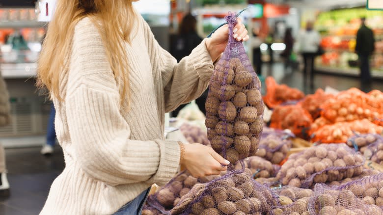 Woman lifting bag of potatoes 