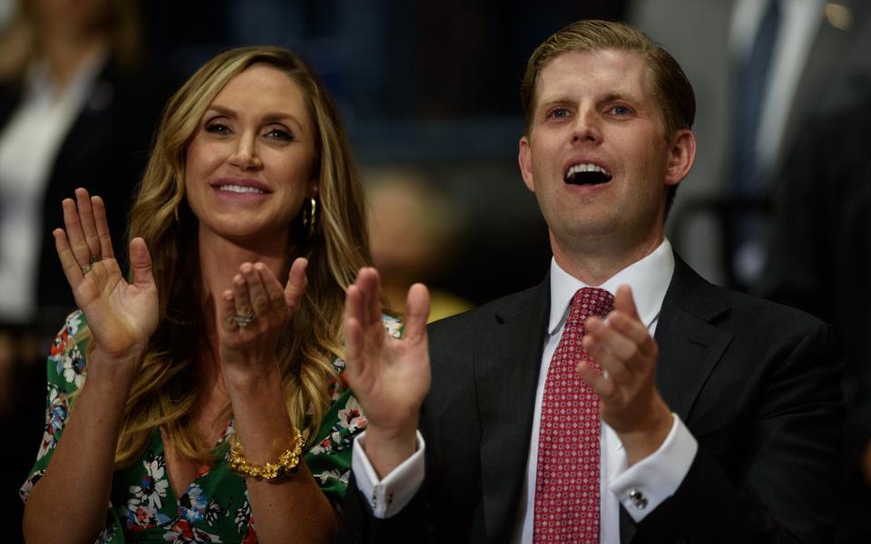 Eric Trump and his wife Lara applaud as Donald Trump addresses a rally in Youngstown in July - Credit: Getty Images