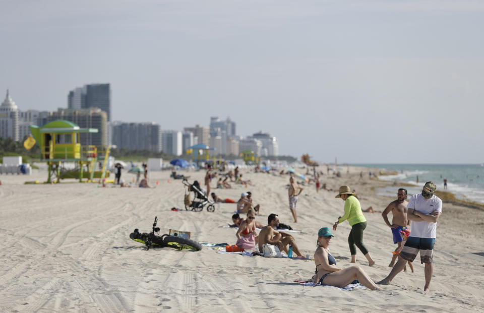 Beach goers enjoy a day on the sand and in the water, Wednesday, June 10, 2020, on Miami Beach, Florida's famed South Beach. Beaches in Miami-Dade County opened with restrictions Wednesday after having been closed for 12 weeks due to the COVID-19 outbreak. (AP Photo/Wilfredo Lee)