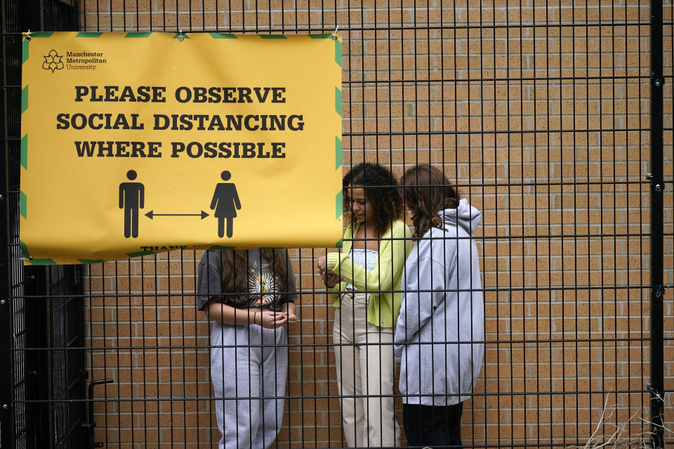 MANCHESTER, ENGLAND - SEPTEMBER 28: Students who are self-isolating stand behind the security fencing of theoir accommodation as they are interviewed by a television crew on September 28, 2020 in Manchester, England. Around 1,700 students across two student housing blocks were told to self-isolate after more than 100 students recently tested positive for Covid-19. The students were told to self-isolate for 14 days even if they were not experiencing symptoms. (Photo by Christopher Furlong/Getty Images)