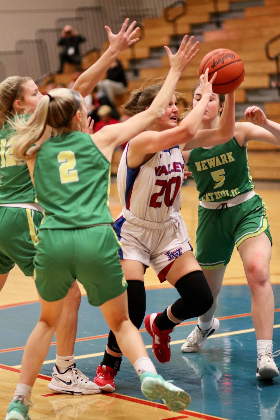 Licking Valley junior Rylee Hillis drives into the paint between Newark Catholic sophomore Sophie Peloquin (2) and senior Maddie Kauble (5) during their Licking County League game on Tuesday, Dec. 6, 2022. The visiting Green Wave picked up a 48-27 victory.