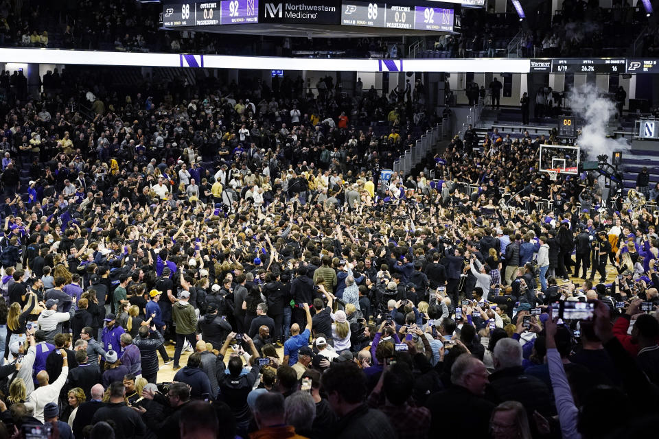 Northwestern players celebrate with fans after Northwestern defeated Purdue 92-88 in overtime during an NCAA college basketball game in Evanston, Ill., Friday, Dec. 1, 2023. (AP Photo/Nam Y. Huh)