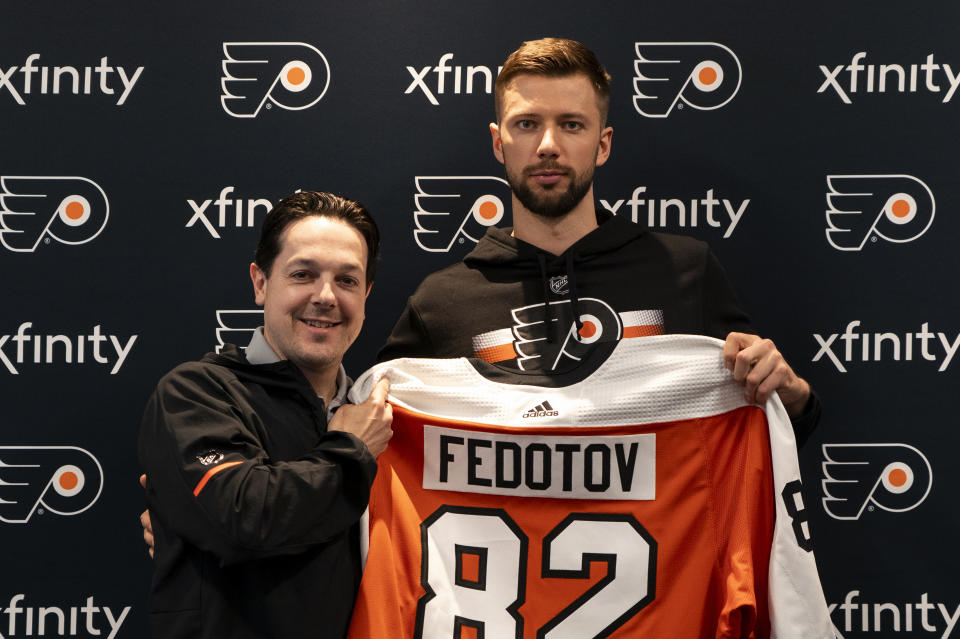 Philadelphia Flyers general manager Daniel Briere, left, and Ivan Fedotov pose with Fedotov's Flyers jersey during an NHL hockey press conference, Friday, March 29, 2024, in Voorhees, N.J. Nine years after he was drafted by Philadelphia, goalie Ivan Fedotov has joined the Flyers.(AP Photo/Chris Szagola)